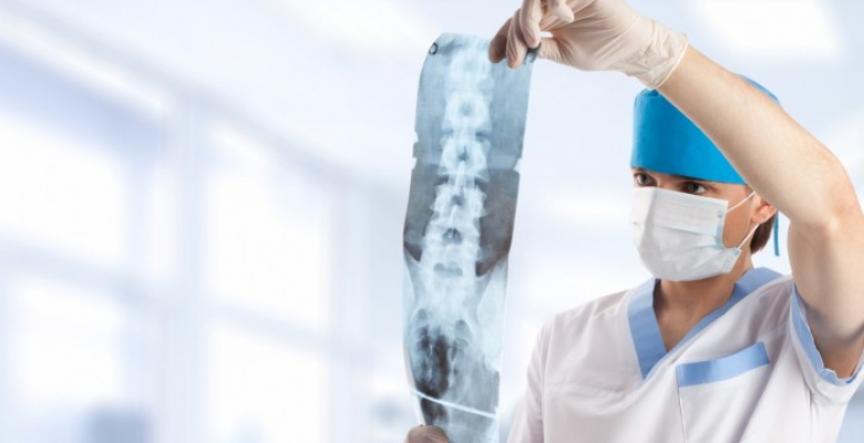 medical doctor looking at x-ray picture of spinal column in hospital with copy space