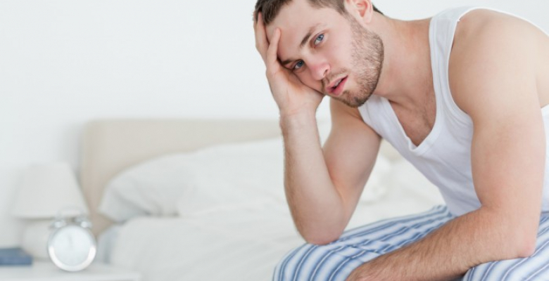 Sick man sitting on his bed